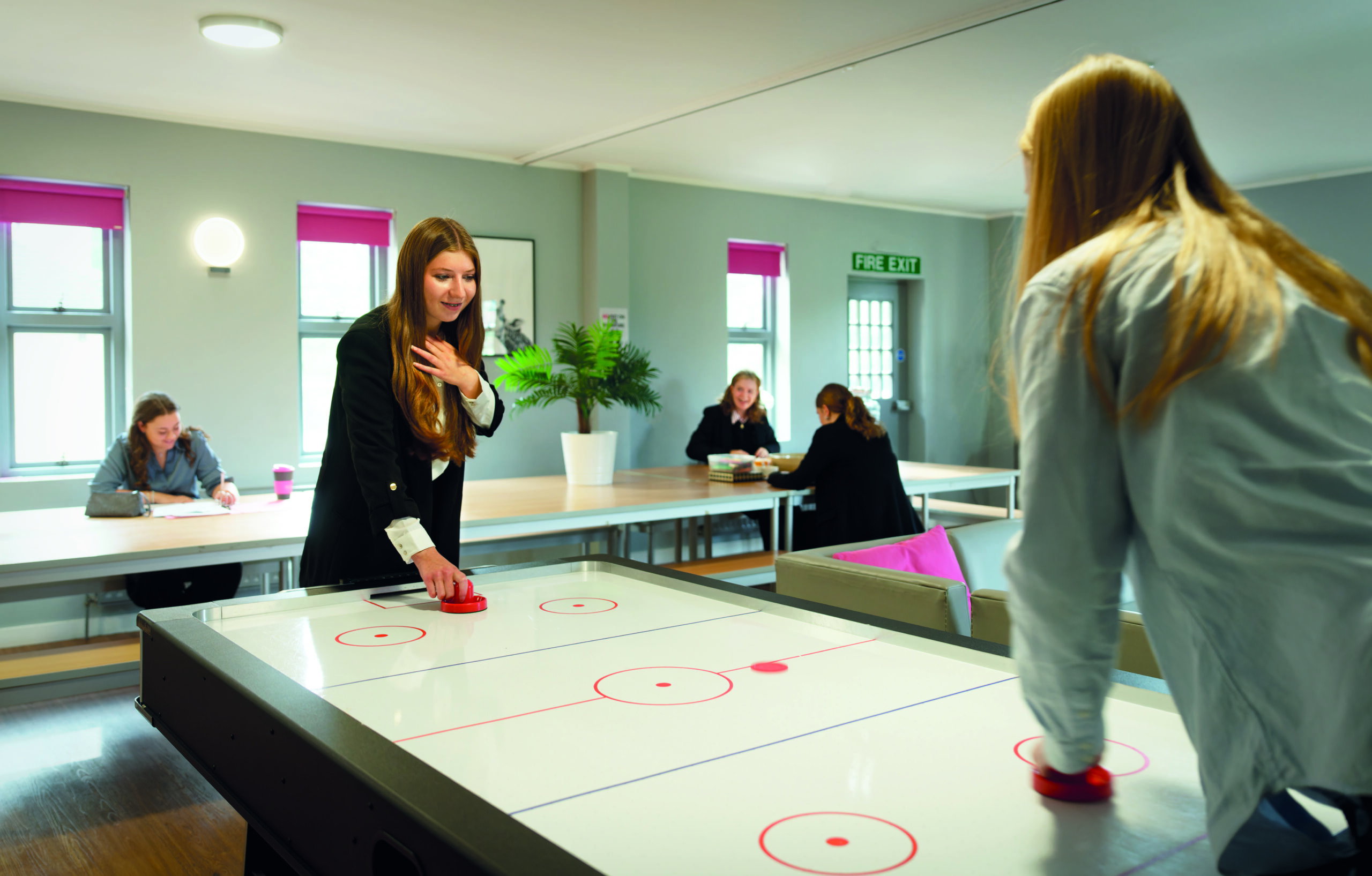 Prior's Field Sixth Form Students playing air hockey